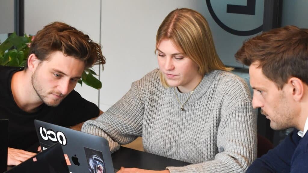 Two designers comparing work at a desk, illustrating product designer vs UX designer role differences