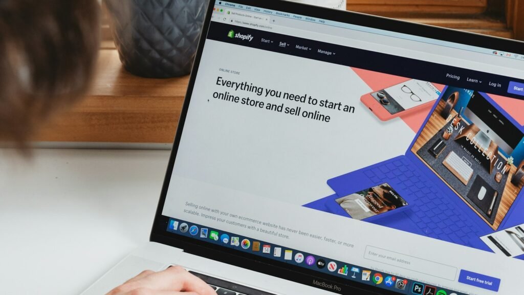 Designer reviewing UI/UX portfolio examples on a laptop